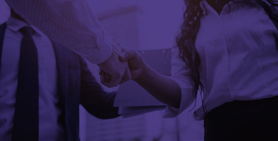 Man and woman shaking hands to enter into a reseller relationship with Kaplan's Reseller Partner Program
