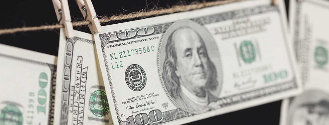 100 dollar bills hanging on a clothes line to represent money laundering