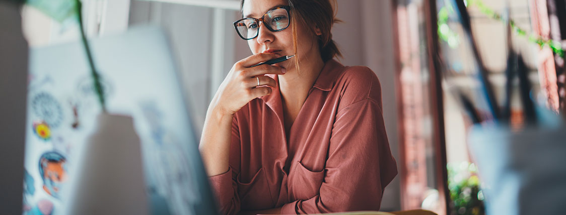 Woman sitting at desk looking at computer monitor image