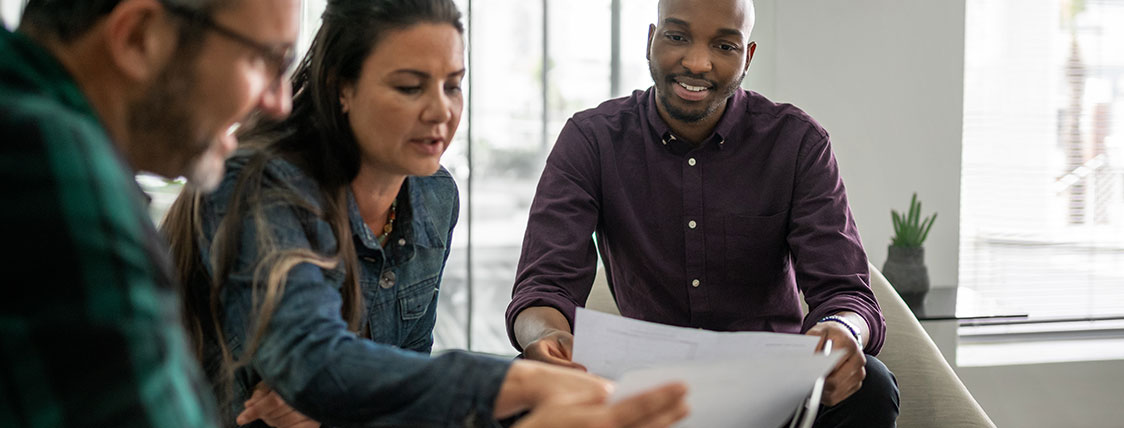 Three colleagues looking at documents together image
