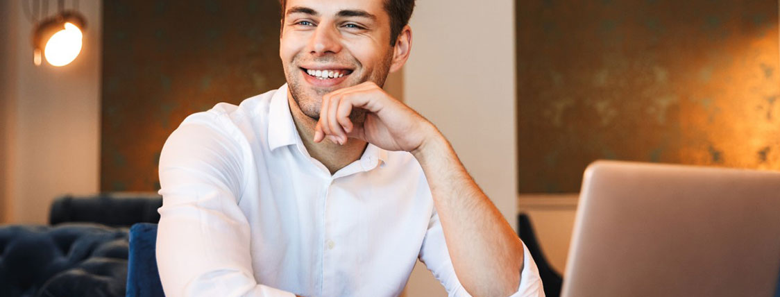 Man sitting in front of laptop with chin resting on his hand image