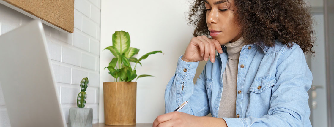 Woman sitting at a desk working on a laptop image