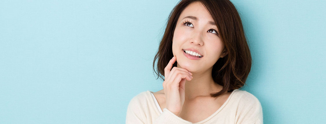 Woman with a quizzical expression looking upward with hand on her chin image