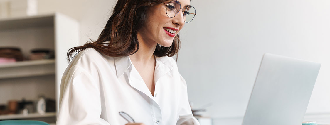 Woman sitting at a desk working on a laptop image