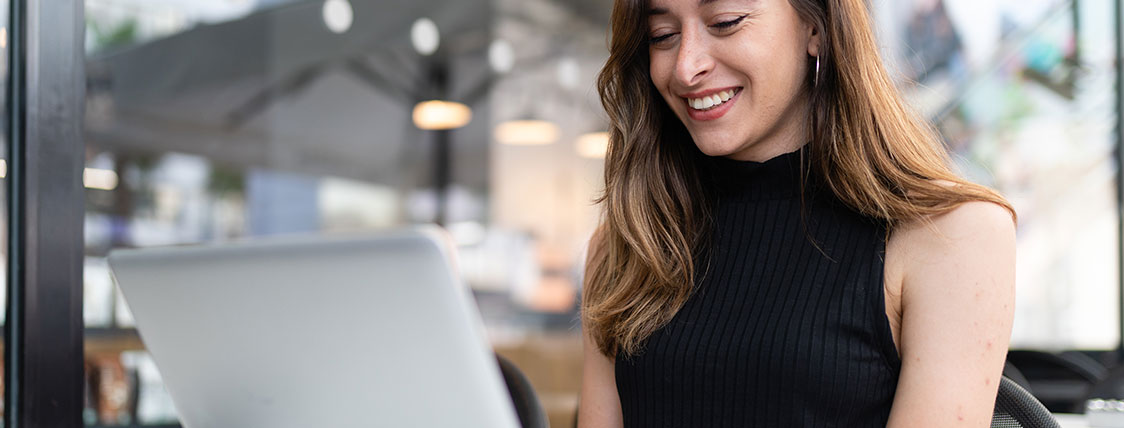 Woman sitting in a coffee shop working on a laptop image