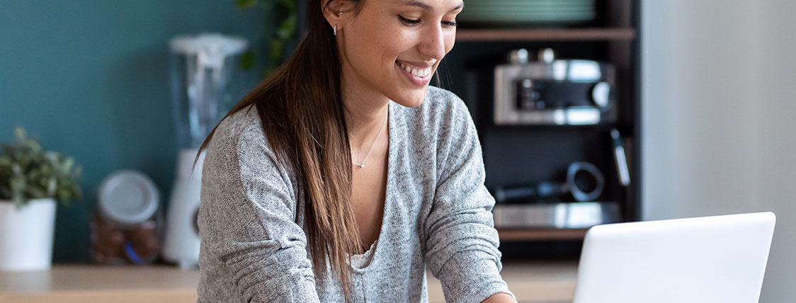 Woman working on a laptop in a kitchen image