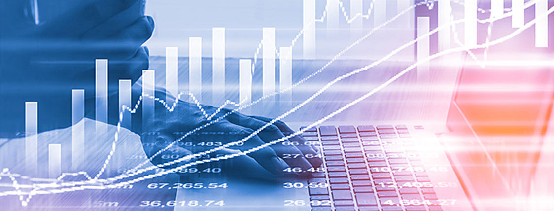 Research analyst reading the day's financial news on a laptop computer