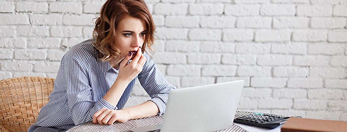 Woman looking at her CFA Exam results on her laptop