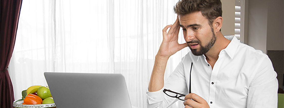 A man at a computer realizing he made one of the 6 common FRM study mistakes